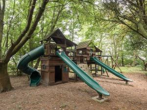 Wainfleet All SaintsにあるNortholme Hallの2つの滑り台と家がある遊び場