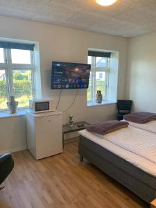 Un dormitorio con dos camas y un televisor de pantalla plana. en House on Vellingtoft in Kværs - apartments, en Gråsten