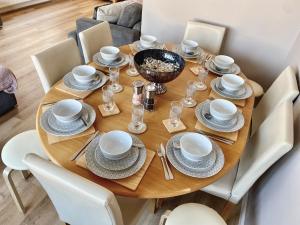 a wooden table with plates and dishes on it at Beach Haven - Uk42241 in Littlestone-on-Sea