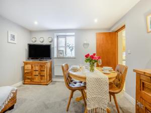 LlansilinにあるCoed Y Gaer Annexe - Uk43776のテーブルと椅子とテレビのあるダイニングルーム