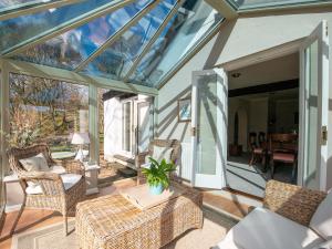 un salón acristalado con techo de cristal, sillas y mesa en Lookin How, en Dockray