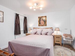 Un dormitorio blanco con una cama y una silla. en The Old Barn - Uk40948, en Auchtermuchty