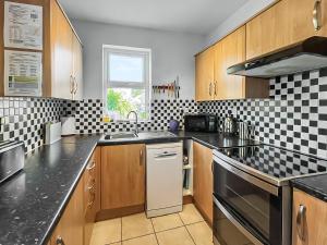 a kitchen with black and white tiles on the wall at Lancashire And Yorkshire Cottage in Hellifield