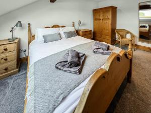 a bedroom with a large bed with towels on it at Lancashire And Yorkshire Cottage in Hellifield