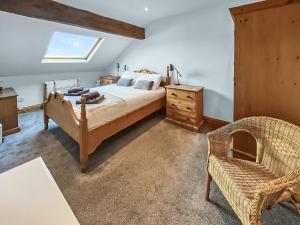 a bedroom with a bed and a chair at Lancashire And Yorkshire Cottage in Hellifield +16 photos