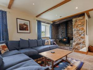 sala de estar con sofá azul y chimenea de piedra en Penmynydd Uchaf, en Dinas 26 fotos más