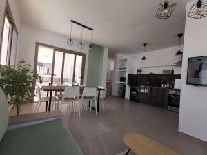 Una cocina y una sala de estar con mesa y sillas. en Au cœur de Demina, en Demina