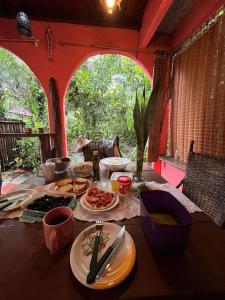 - une table avec des assiettes de nourriture dans une pièce dans l'établissement Casa da Mel, um refúgio cercado pela natureza, à Cairu