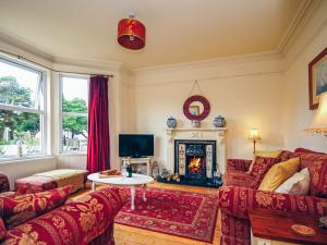 a living room with a couch and a fire place at Captain's House in Morfa Nefyn