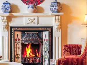 a fireplace in a living room with a fire at Captain's House in Morfa Nefyn