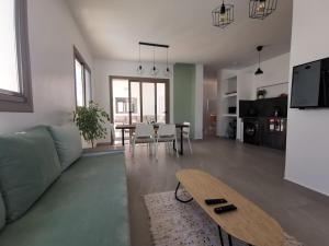 una sala de estar con un sofá y una mesa en Au cœur de Demina, en Demina