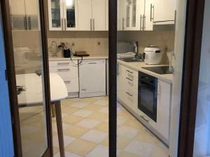 a kitchen with white cabinets and a table in it at Chambre Privée Cosy- Dans Appartement Moderne en Colocation- Tram A -P2-4 in Lormont