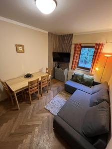 Una sala de estar con un sofá y una mesa de comedor. en Apartmány Pod Javorem, en Pec pod Sněžkou