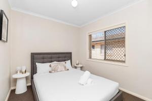 Una habitación blanca con una cama y una ventana en Wagga CBD Apartments, en Wagga Wagga