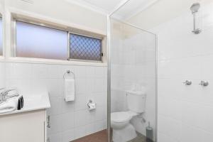 Un baño con inodoro y ducha de cristal. en Wagga CBD Apartments, en Wagga Wagga 7 fotos más
