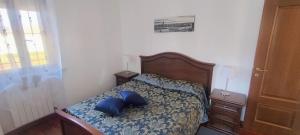 a bedroom with a bed with blue pillows on it at B&B Rivoli in Rivoli +10 photos