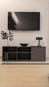 ein schwarzes Entertainment-Center mit einem Flachbild-TV an der Wand in der Unterkunft La casa degli Archibugi in Sulmona