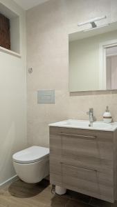 ein Badezimmer mit Toilette, Waschbecken und Spiegel in der Unterkunft La casa degli Archibugi in Sulmona