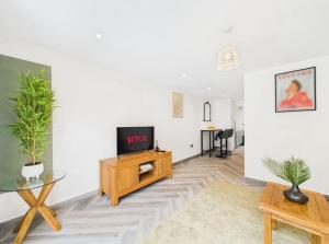 a living room with a tv and a table at Elegant 3-Bed Near Station, Pantiles & Calverley in Royal Tunbridge Wells