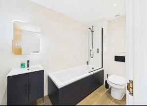 a bathroom with a tub and a toilet and a sink at Elegant 3-Bed Near Station, Pantiles & Calverley in Royal Tunbridge Wells +13 photos