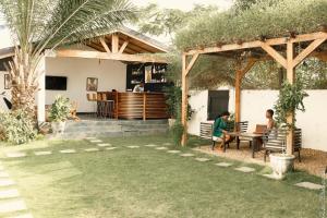 two people sitting at a table in a backyard at Ahomé Guest house & Lounge in Lomé