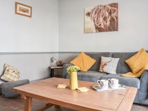 a living room with a couch and a wooden table at Elms Cottage - Sadberge in Long Newton