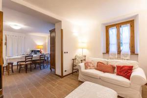 a living room with a white couch and a dining room at Casale il Gugnolo in Castiglione dʼOrcia