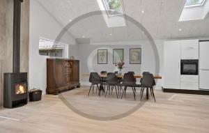 a dining room with a table and a fireplace at Gorgeous Home In Spøttrup With Sauna in Vester Lem