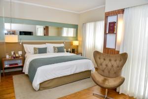 una camera da letto con un letto grande e una sedia di Clarion Faria Lima a San Paolo