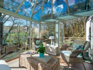 un salón acristalado con techo de cristal, sillas y mesa en Lookin How, en Dockray