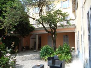 une cour avec un arbre et un bâtiment dans l'établissement FeWo Luino Loft, à Luino