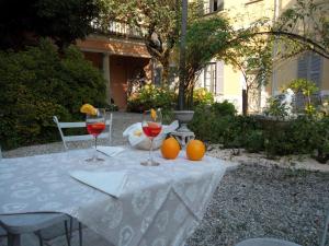 - une table avec deux verres de vin et des oranges dans l'établissement FeWo Luino Loft, à Luino
