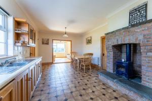 a kitchen with a brick fireplace and a dining room at Ballyneill Farmhouse in Carrick-on-Suir