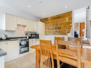 キャッスルトンにあるColtus Landsの木製のテーブルと椅子のあるキッチンとダイニングルーム