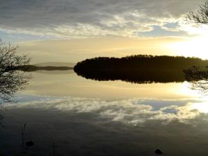 a view of a lake at sunset at Tarandoun Cottage in Helensburgh +1 photo