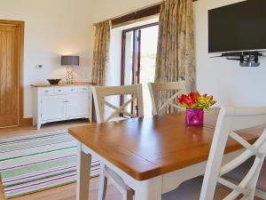 a dining room with a wooden table and chairs at Swallows Retreat in Hartland