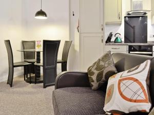a living room with a couch and a table at Scullery Cottage in Penrhyn Bay