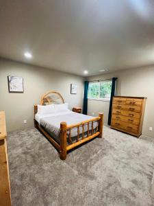 a bedroom with a wooden bed and a dresser at Rest and Retreat River House in Grants Pass