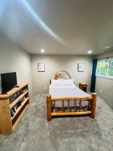 a bedroom with a bed and a flat screen tv at Rest and Retreat River House in Grants Pass