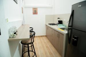 a kitchen with a refrigerator and a counter with stools at CASA ROOSEVELT in Cali