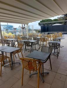 a group of tables and chairs on a patio at Bungalow 507 3ch wifi Camping Siblu Lac de Rêves in Lattes