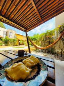a table with two pillows on top of a patio at Chale Pitanga 38 in Pipa