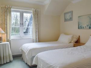 two beds in a room with a window at Oaklands in Ambleside