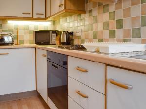 a kitchen with a stove and a counter top at Oaklands in Ambleside