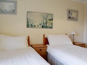 a bedroom with two beds and a painting on the wall at Oaklands in Ambleside