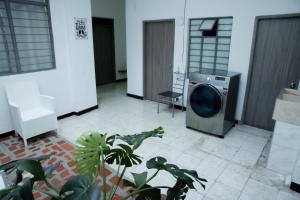 a washing machine in a room with a plant at CASA ROOSEVELT in Cali +4 photos