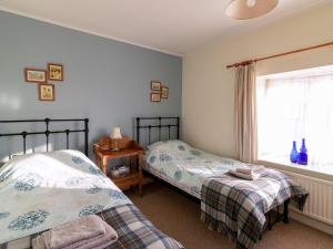 MathryにあるLittle Roostのベッド2台と窓のある寝室