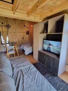a living room with a flat screen tv on a wall at KUNTUR 2 Cabañas in El Chalten