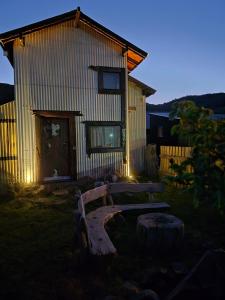 a wooden bench in front of a building with lights at KUNTUR 2 Cabañas in El Chalten