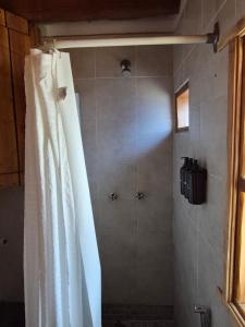 a shower with a shower curtain in a bathroom at KUNTUR 2 Cabañas in El Chalten +12 photos
